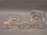 three clear glass bottles with gold lids on a table