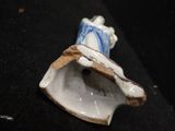 a small figurine of a woman with a blue and white dress