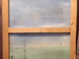 an old painting is sitting on the floor in front of a wall