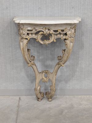 an antique console table with a marble top and ornate carvings