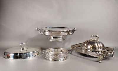 des assiettes et des plateaux en métal argenté posés sur une table avec un fond blanc