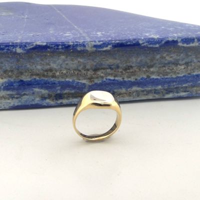 an image of a gold ring with a stone in the background