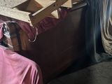 un homme assis sur une chaise à côté d'un tas de bois