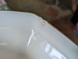 a white bowl with a brown rim sitting on a table