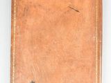 an old book with a brown cover sitting on top of a white table