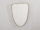 un miroir plaqué or accroché à un mur blanc