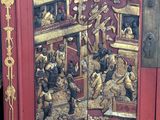 a red cabinet with a gold design on it
