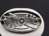 une broche en argent munie d'une épingle métallique