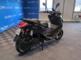 a scooter that is parked in front of a blue wall