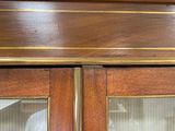 a close up of a wooden cabinet with glass doors