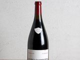 a bottle of red wine sitting on a wooden table