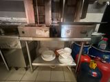 de nombreuses assiettes et casseroles posées sur une étagère métallique dans la cuisine