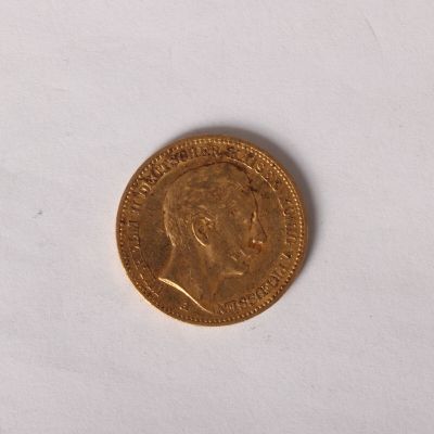 gros plan d'une pièce d'or sur une surface blanche