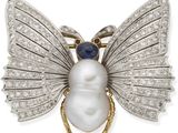 un gros plan sur une broche en forme d'insecte, composée d'une perle blanche et de diamants