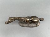 a bronze statue of a horse laying down on the ground
