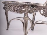 a silver plate with a candle on it on a stand