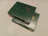 two green books sitting on top of each other on a table