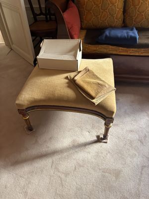 un petit banc sur lequel est posé un coffret, dans un salon