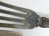 a silver fork and a silver spoon on a white surface