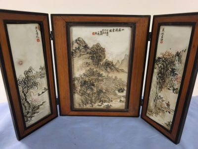 trois tableaux asiatiques encadrés représentant un paysage de montagne, posés sur une table