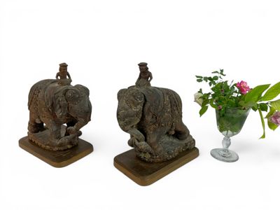 two figurines of elephants and a vase of flowers