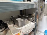 many pots and pans on the shelves in the kitchen