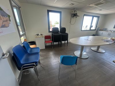 une pièce avec des chaises et une table, et un tableau accroché au mur