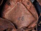 a close up view of a leather hat with a face on it