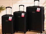 trois bagages posés sur un parquet, à côté d'une plante
