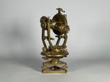 un télescope ancien en laiton posé sur un socle, sur fond blanc