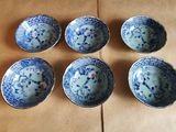 six bols bleus et blancs posés sur une table en bois