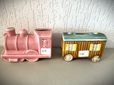 deux petits trains en céramique posés l'un à côté de l'autre sur une table