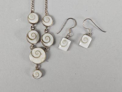 a close up of a necklace and earrings on a table