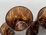 three glasses that are sitting on a white surface