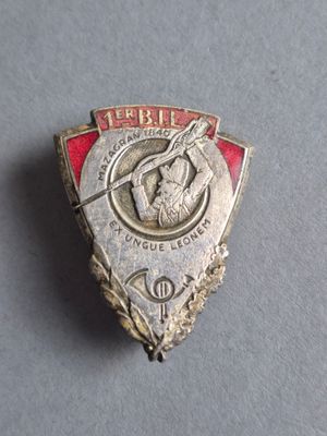 une image représentant un insigne argenté et rouge sur un fond gris