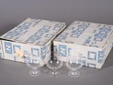 une paire de verres à vin vides posés devant une boîte de verres à vin vides