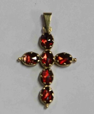 un gros plan d'une croix composée de pierres rouges sur une surface blanche