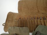 a roll up tool bag with a bunch of tools inside of it