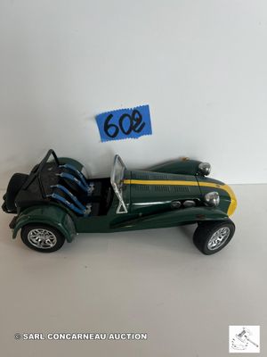 une petite voiture verte sur laquelle figure un numéro