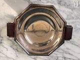 a silver plate with a wooden handle on a marble table