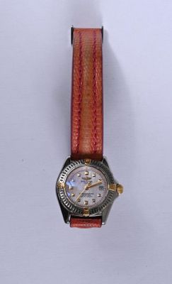 une montre montée sur un bracelet en cuir rouge