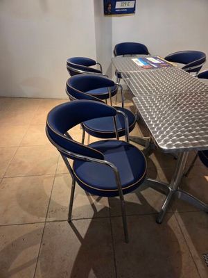 une table entourée de six chaises bleues dans une pièce