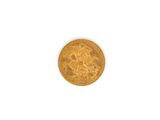 gros plan d'une pièce d'or sur une surface blanche