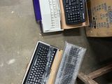 a computer keyboard and a laptop sitting on the floor