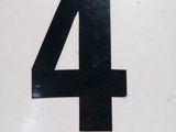 a black number four on the side of a white plate