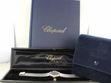 a watch in a case and a wallet on a table