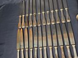 a lot of silver spoons and knives on the table