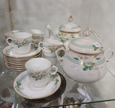 une vitrine en verre dans laquelle sont exposées diverses tasses à thé et soucoupes