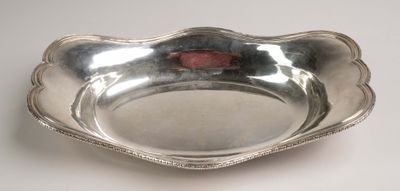 un plat ancien en argent orné d'une rose rouge au centre
