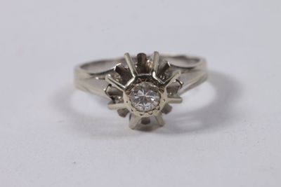 a close up of a diamond ring on a white surface
